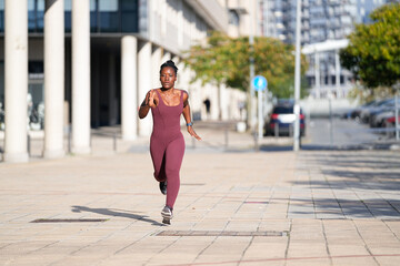 Young afro american sportswoman running in the city center