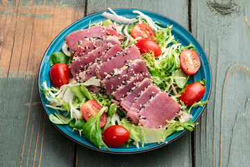 Salad with raw tuna , sesame and cherry tomatoes photography . Top view