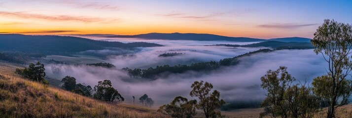 Obraz premium Misty valleys and rolling hills stretch across the landscape, illuminated by the soft hues of dawn, creating a serene countryside view. Generative AI