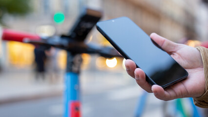 Tourist using smartphone application for renting electric scooter in the city