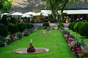 beautiful flower beds with fountains in the park against the backdrop of light umbrellas from the...