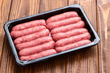 Raw beef sausages with rosemary and tomatoes photography . Top view