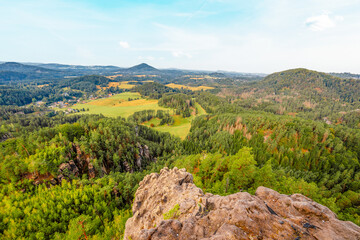 Naklejka premium Hiking to Maria or Mariina skala wooden viewpoint built on a rock. It offers a beautiful view of the town of Jetrichovice in Bohemian Switzerland