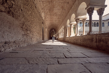 Man senior walk in 4th century monastery with architectural details