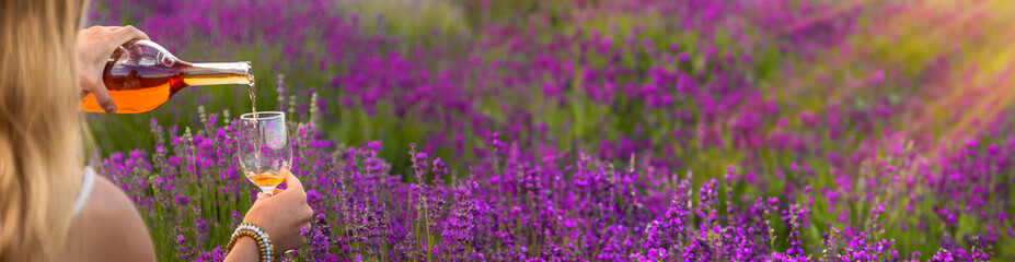 Obraz premium Woman with wine in lavender field wine. Selective focus.