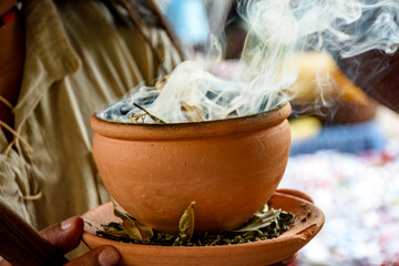 Aromatic herbs burning from a clay pot at the Umbanda smoking ceremony in Brazil