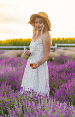 Woman with wine in lavender field wine. Selective focus.