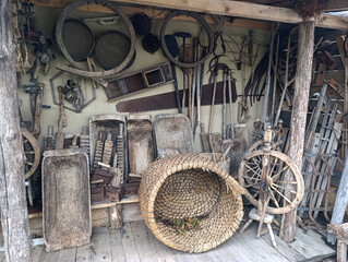 A wooden shed filled with lots of old tools and a basket