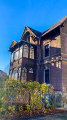 A large brown house with a blue sky in the background