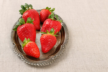 Bowl with strawberries on white wooden table.