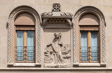 Beautifully carved stone relief above windows in historic building