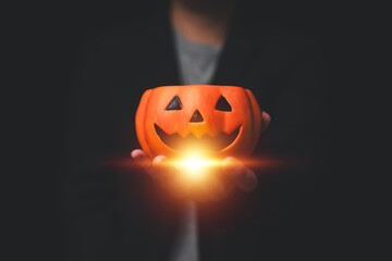 Man in formal mourning attire with Halloween pumpkin, Low key
