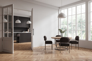 Modern dining area with large windows, connected to a stylish black kitchen with pendant lights. 3D Rendering