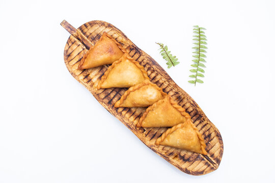 Chicken puli pitha fried served on wooden board isolated on white background top view of indian, pakistani and bangladeshi food