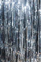 Close-up of shimmering silver metallic strips creating a reflective and sparkling texture. Ideal for festive backdrops, abstract art, or glamorous event decoration with a modern, vibrant look.