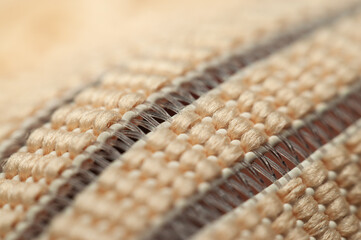 Close-up view reveals intricate beige fabric weave