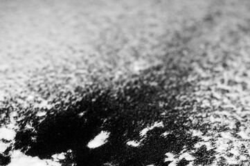 White powder spills onto a dark surface