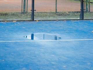 outdoor padel court with a blue surface, equipped with net floodlights and glass © manola72
