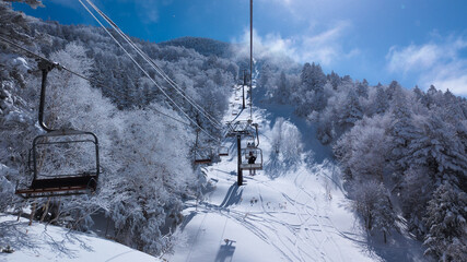 Skiers on a chairlift at the Shibutoge ski area, Nagano, Japan