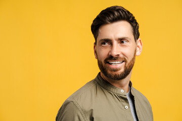 Portrait of smiling, attractive, bearded man, fashion model looking away, isolated on copy space