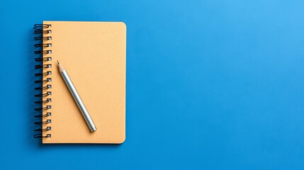 Blank notebook with a pencil on a blue background.