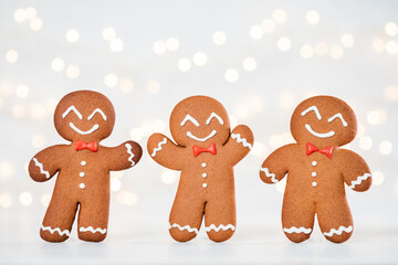 Fototapeta premium Three gingerbread men are smiling and wearing bow ties