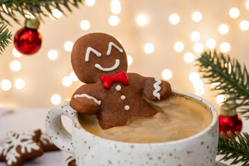 A gingerbread man is sitting in a cup of coffee