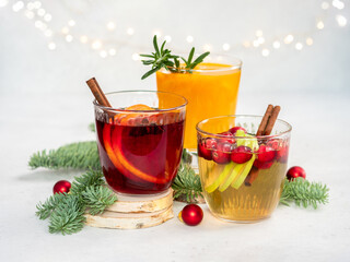 Three drinks with cranberries and cinnamon are on a table