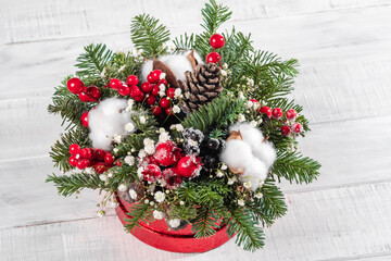 A red box with white flowers and pine cones inside