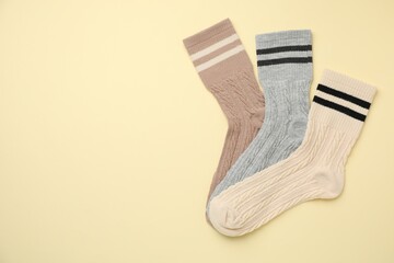 Different comfortable socks on beige background, flat lay. Space for text