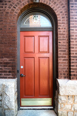 Old wooden front door with steps to brick house .