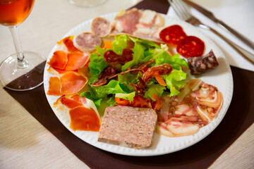 Typical Catalan salad with lettuce, tomato, olives and onion accompanied by various types of sausages.