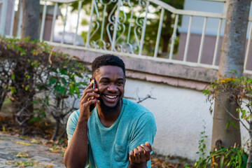 Young African American guy using mobile phone