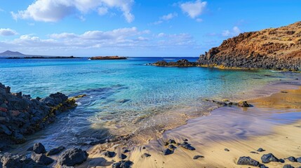 A serene sandy beach scene with large rocks and calm clear water