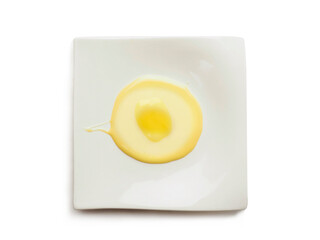 Condensed milk and custard desert looks like a fired egg on a white fancy square plate and light background. Creative food ideas. Light and airy look