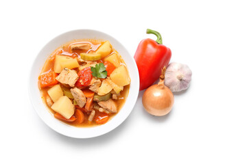 Bowl with delicious beef stew and different ingredients on white background