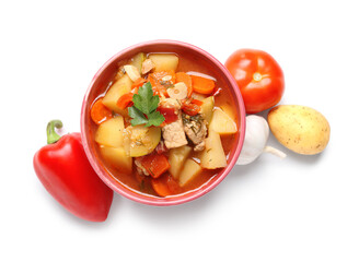 Bowl with delicious beef stew and different ingredients on white background