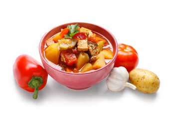 Bowl with delicious beef stew and different ingredients on white background