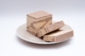 Tahini halva in slices on a white background