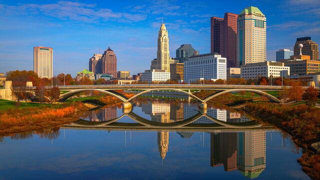 Columbus Ohio Skyline, Skyscrapers, and Landmark Buildings, USA: A vibrant tranquil beauty over the serene Scioto River water and green space in autumn