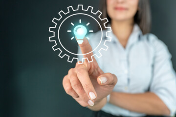 innovation idea and knowledge concept. Hand touch gear icon in light bulb icon of ​​inspiration thinking.