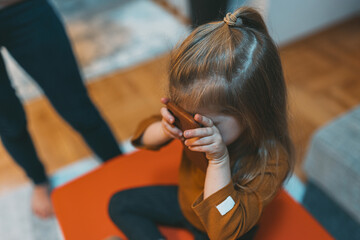 A child sits and interacts with a smartphone, deeply engrossed in the digital world, highlighting...