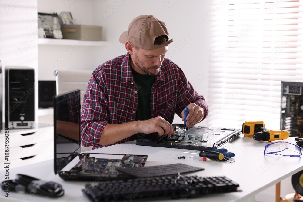 Poster man fixing computer monitor at white table