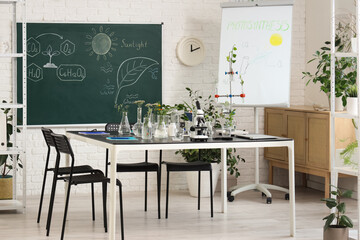 Interior of Biology classroom with table, blackboard and plants
