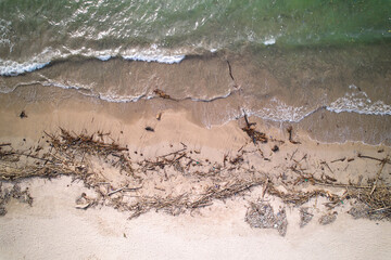 An top view of a polluted beach. Ocean waves bring garbage to the shore.The problem of ecology and pollution of nature and the planet.
