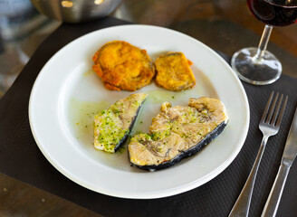 Delicious fried swordfish fillet served with breaded eggplant on plate