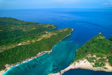 Cinematic aerial landscape shots of the beautiful island Diamond beach of Nusa Penida. Huge cliffs by the shoreline and hidden dream beaches with clear water.