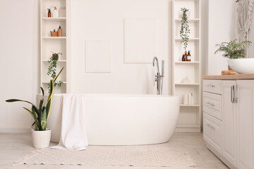 Bathtub, counter with sink and shelving units in interior of bathroom