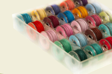 sewing bobbins with colored threads red, blue, green