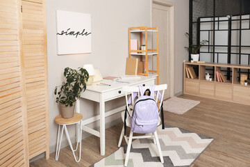 Interior of student's room with workplace, bookshelf and door